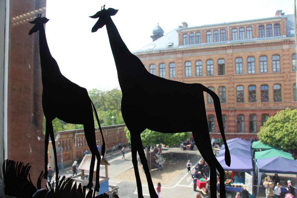 Blick aus einem Klassenzimmer in den Schulhof mit Sommerfest der Eisgrubschule